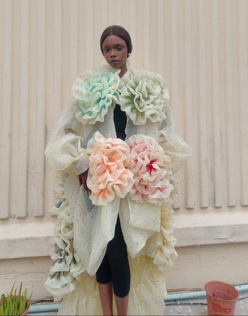 Person wearing a floral coat with a neutral background